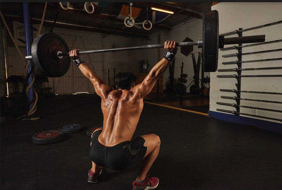 Man performs squat lift with bar